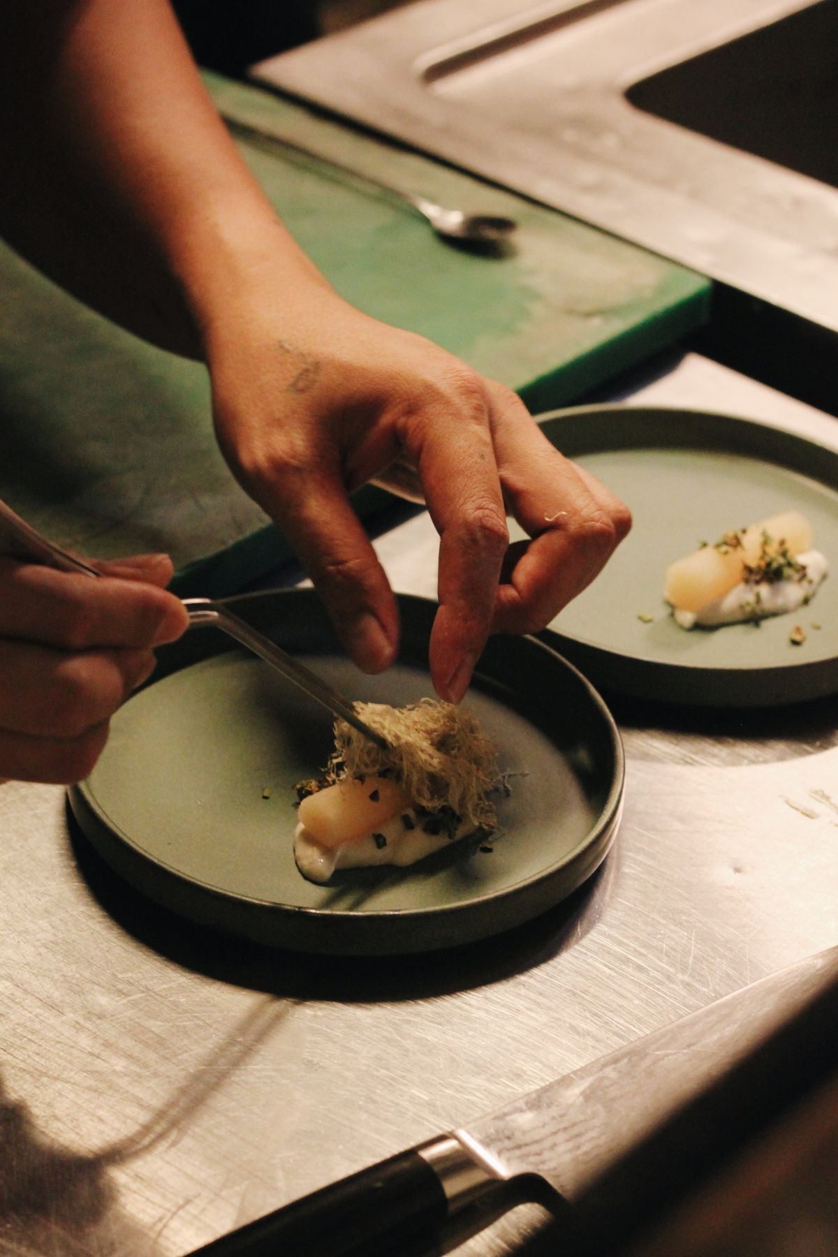 Chef emplatando un plato con cuidado en la cocina de un restaurante