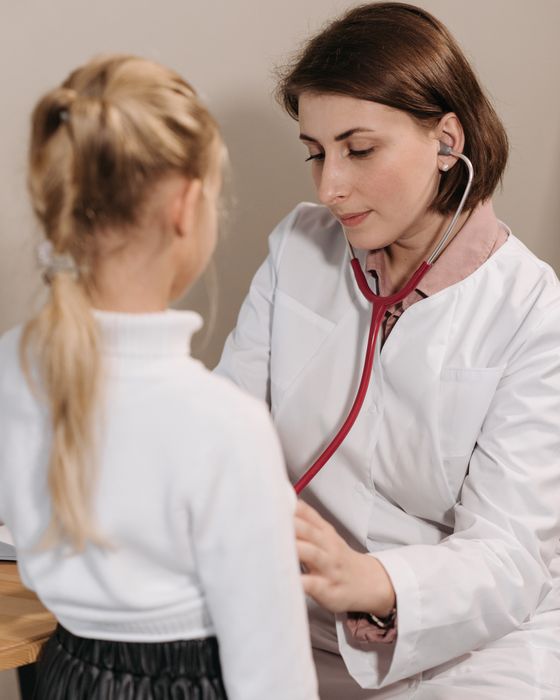 Pediatra examinando a una niña con estetoscopio