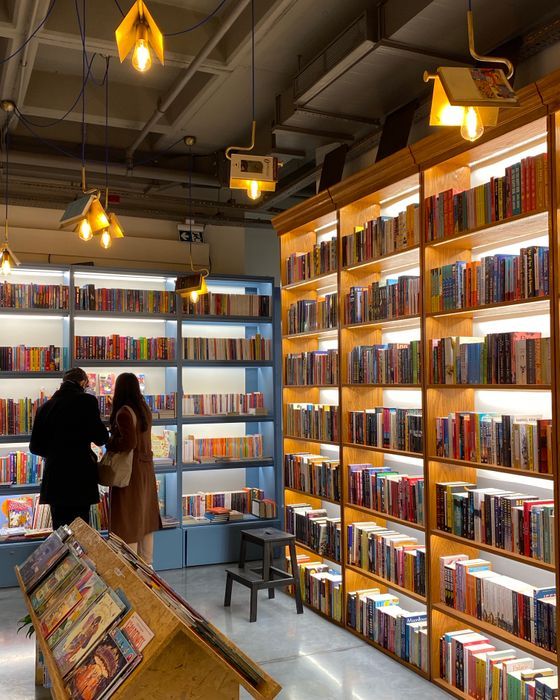 Personas ojeando libros en los estantes de una librería