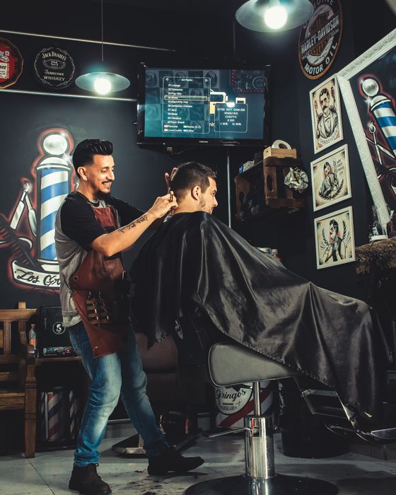 Barbero cortando el cabello de un cliente