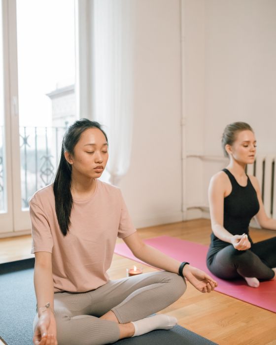 Dos personas meditando en posición de loto en una clase de mindfulness