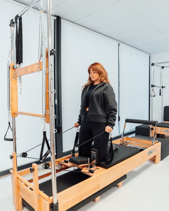 Mujer ejercitándose en una máquina reformer de pilates